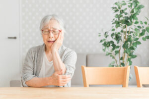 入れ歯の痛みを耐える女性