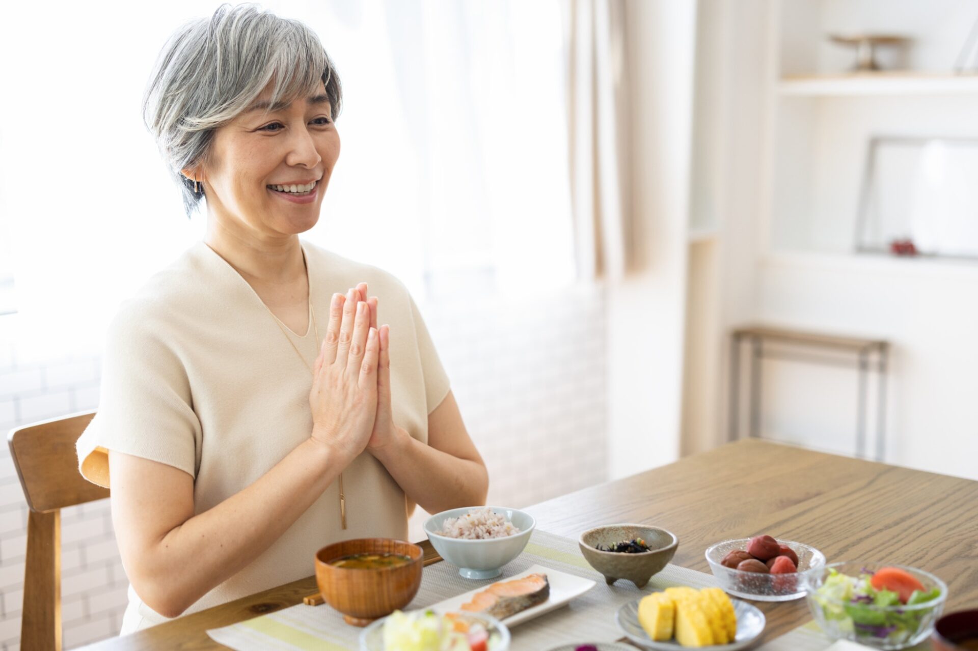 自宅で食事を楽しむ高齢女性の健康的な食生活イメージ