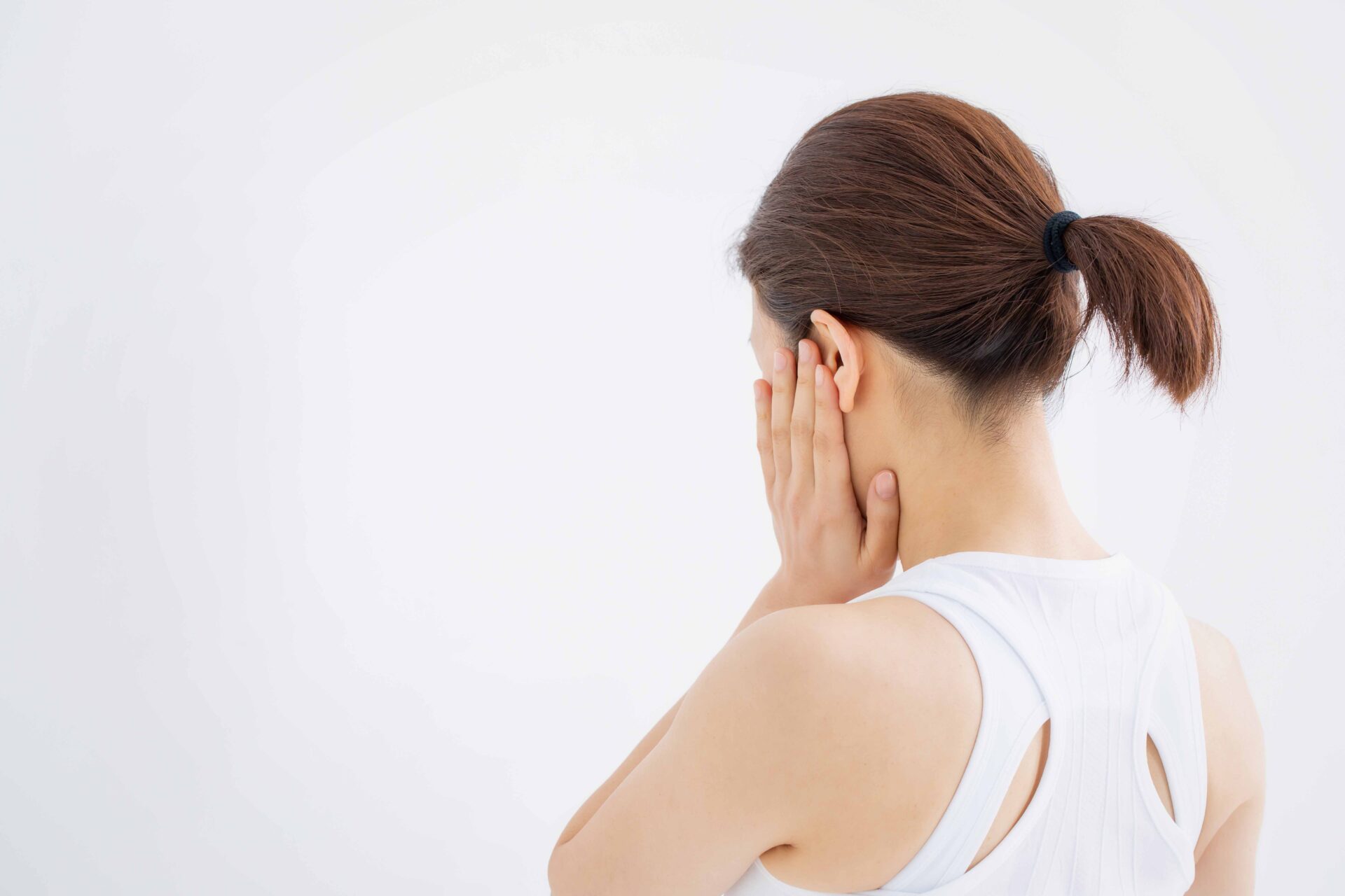 顎関節や歯の痛みに悩み耳周辺を押さえる女性