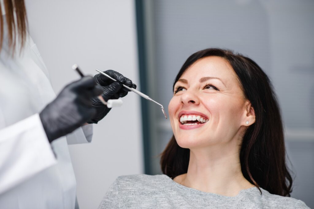 白衣を着た医師によって歯の治療を受ける女性