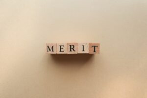 四角い木目の上に英単語でMERITと文字が書かれている