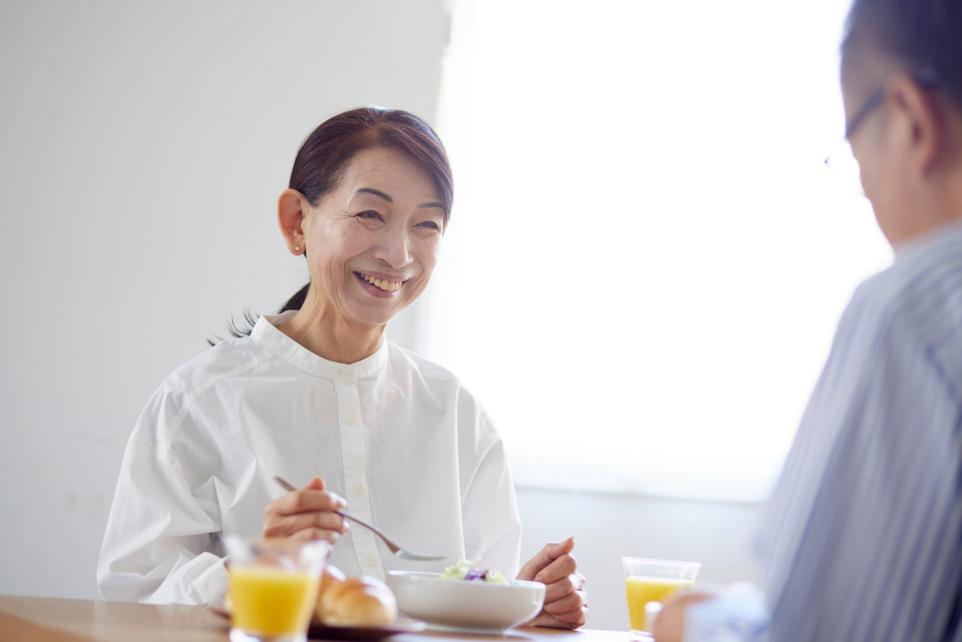 リビングで朝食を食べる日本人のシニア夫婦