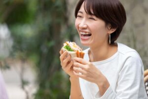 虫歯の再発を予防して笑顔で食事を楽しむ女性