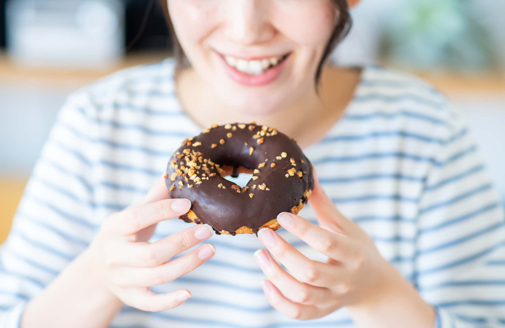 虫歯が再発する原因の一つとなる甘い食べ物を食べる女性