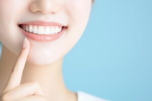 セラミックの前歯を指さす女性