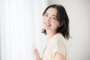 笑顔を見せるインプラントにした女性