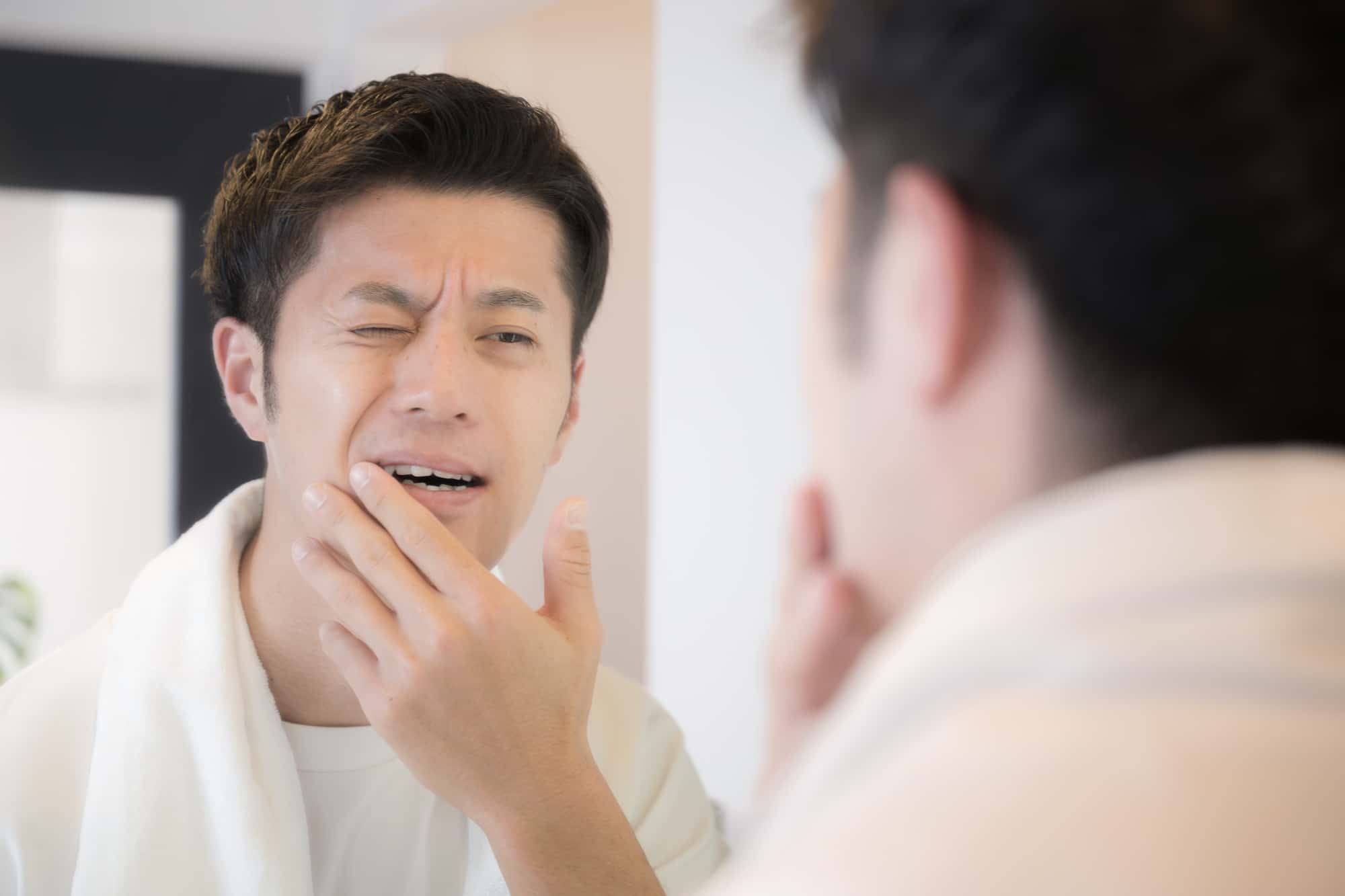 虫歯ができて痛みを感じる男性