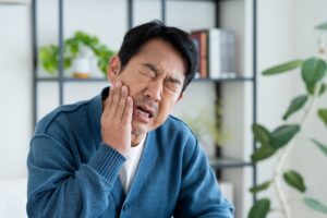 インプラント治療後の痛みに顔をしかめる男性