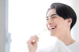 セラミック治療後の歯茎の黒ずみを防ぐために丁寧に歯磨きする男性