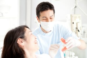 歯科医師からインプラント治療の説明を受け笑顔の女性