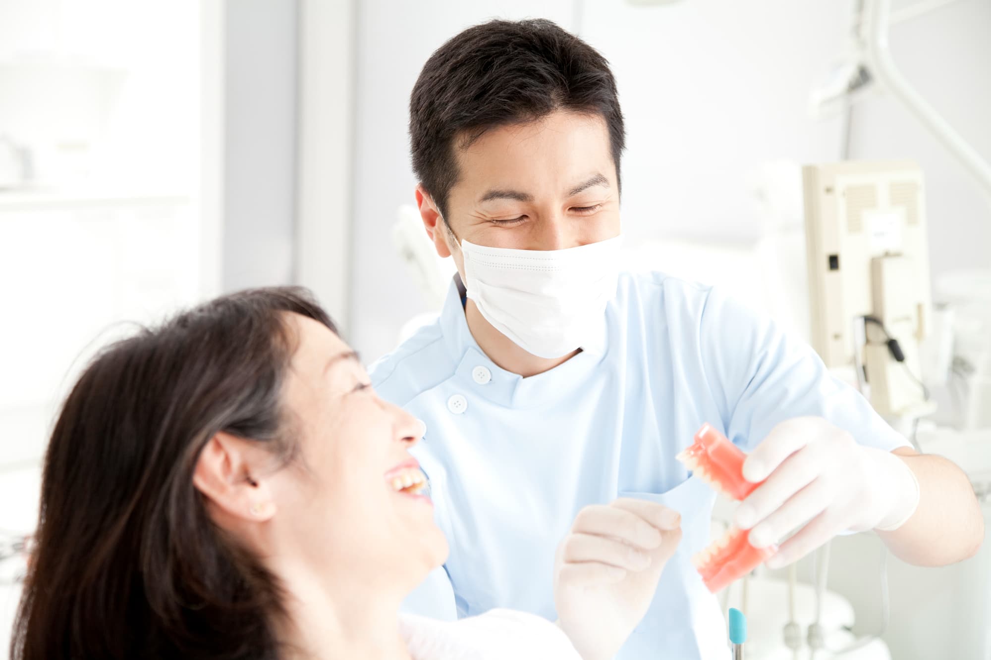 歯科医師からインプラント治療の説明を受ける笑顔の女性