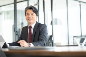 歯周病を治療して口臭がおさまって笑顔で仕事をする男性