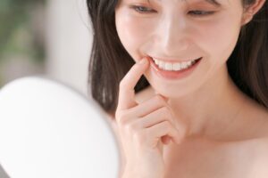 鏡で歯茎を確認する女性