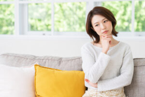 歯の根の先に膿が溜まる原因について考える女性