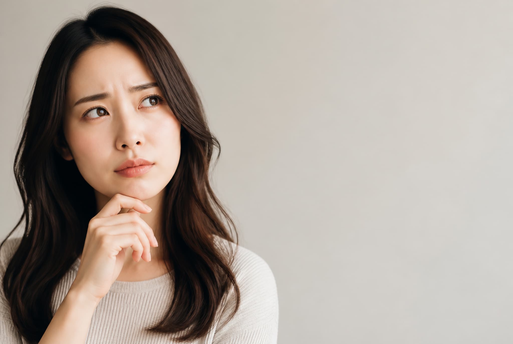 セラミック治療にデメリットがあるのか考える女性